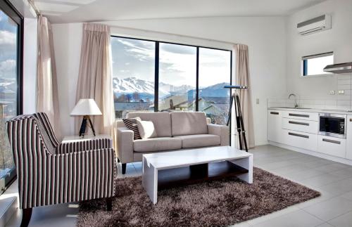 a living room with a couch and a chair and a table at Tenby Apartments in Wanaka