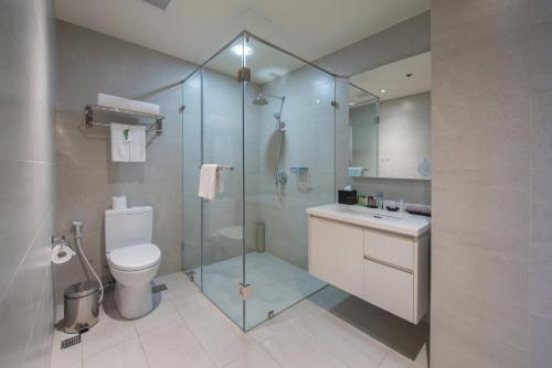 a bathroom with a shower and a toilet and a sink at Citadines Millennium Ortigas Manila in Manila