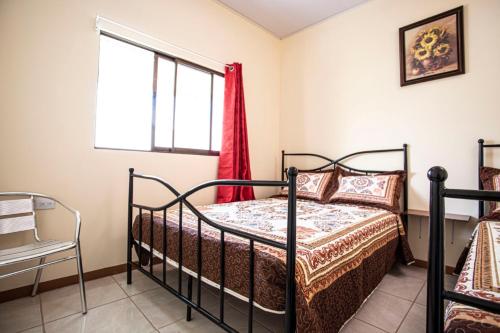 1 dormitorio con cama y ventana en Flor de Katty Hostel Airport, en Alajuela