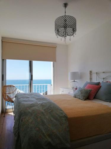 a bedroom with a bed with a view of the ocean at La Dolce Vita in Lagoa