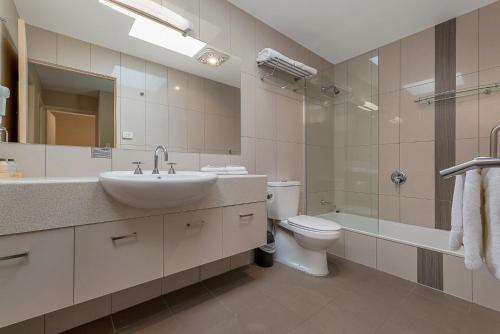 a bathroom with a toilet, sink, and shower at Bay View Villas in Hobart