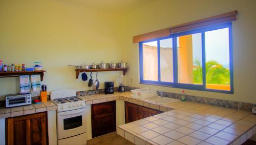 a kitchen with a white stove and a window at Las Turquezas in Puerto Escondido
