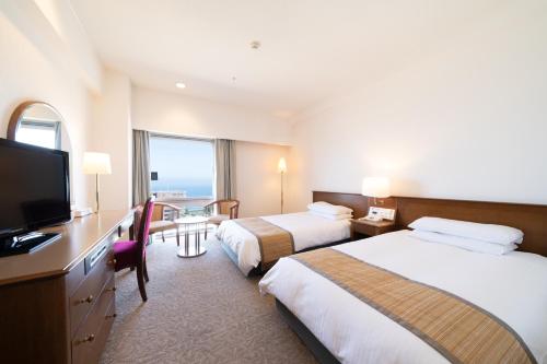 a hotel room with two beds and a flat screen tv at Hotel Terrace The Square Hitachi in Hitachi