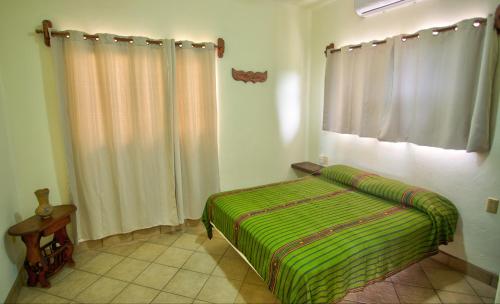 a bedroom with a green bed and a window at Las Turquezas in Puerto Escondido