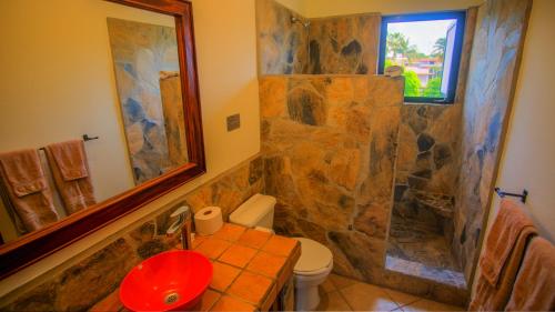 a bathroom with a stone shower and a toilet at Las Turquezas in Puerto Escondido