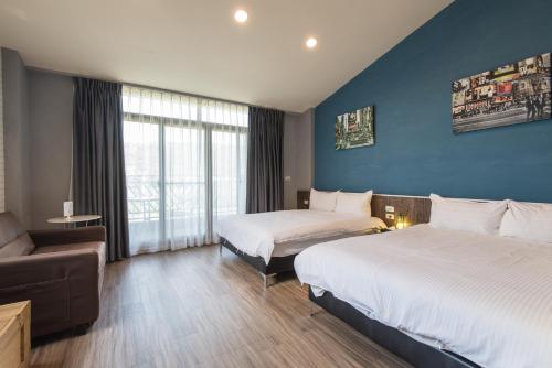 um quarto de hotel com duas camas e um sofá em CT House em Hualien