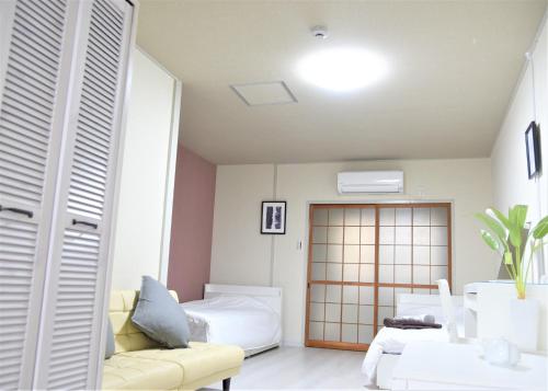 a living room with a bed and a couch and a room at Osaka U-Shuku in Osaka