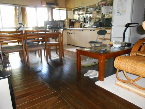 a kitchen with a table and chairs and a dining room at ゲストハウスよろずや in Nahari