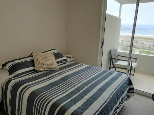 a bedroom with a bed with a view of the ocean at Moderno departamento, inmejorable vista al mar in Los Molles