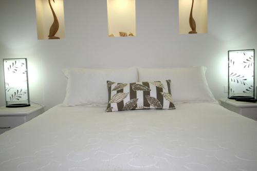 a bedroom with a white bed with two lamps at Mollymook Beach Waterfront in Mollymook