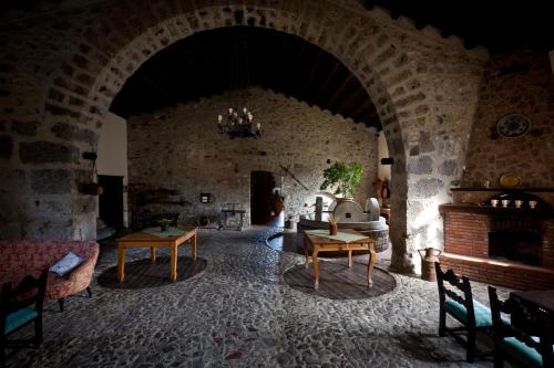 a living room with an archway in a stone building at Il Vecchio Frantoio in Scillato