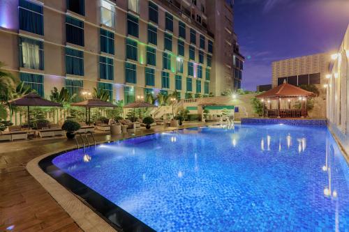 a swimming pool in front of a hotel at night at The Mira Hotel in Thu Dau Mot