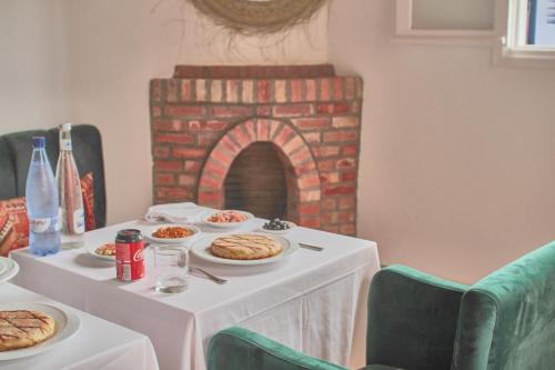 a table with plates of food and a fireplace at Riad Borj El Baroud in Essaouira
