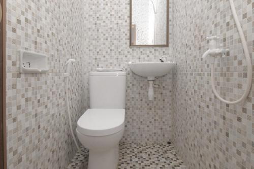 a bathroom with a toilet and a sink at MAMA SYARIAH @ KUTAJAYA in Tangerang