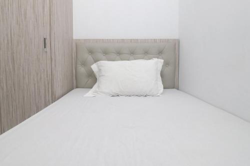 a white bed with a white pillow on it at MAMA SYARIAH @ KUTAJAYA in Tangerang