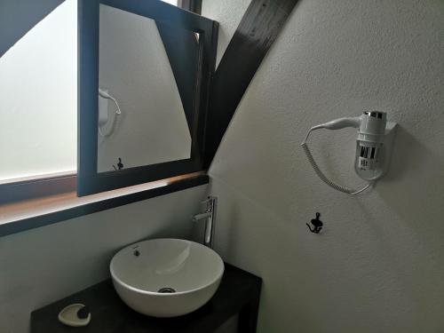 a bathroom with a white sink and a mirror at Hunnia - Huntanya in Vlăhiţa
