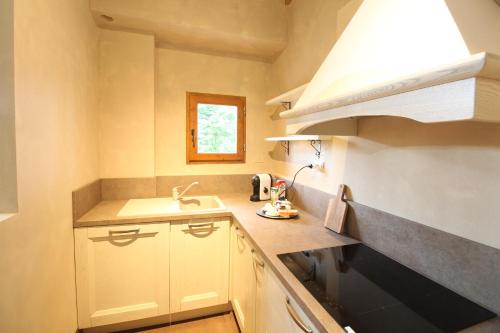 a kitchen with white cabinets and a sink and a window at Villa Leonardo in Vinci