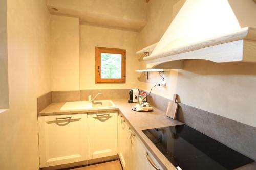 Una cocina con gabinetes blancos y un fregadero y una ventana. en Villa Leonardo, en Vinci