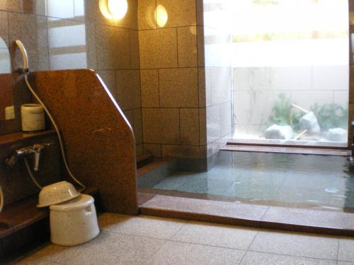 a bathroom with a toilet sitting next to a window at Hotel Route-Inn Tomakomai Ekimae in Tomakomai