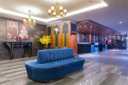 a blue couch in a lobby with a bar at Saint Art Hotel in Beigang
