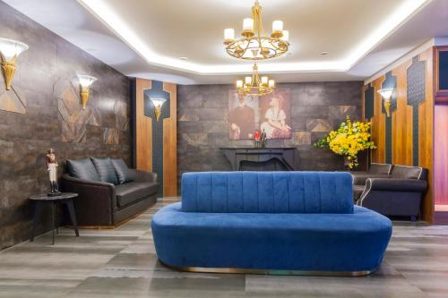 a living room with a blue couch and a fireplace at Saint Art Hotel in Beigang