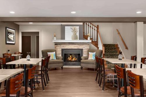 a dining room with tables and a fireplace at Travelodge Suites by Wyndham Moncton in Moncton