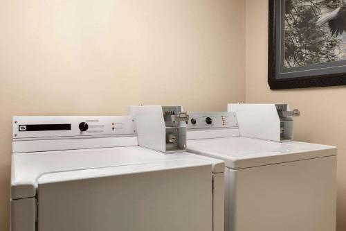 two washing machines sitting next to each other in a room at Travelodge Suites by Wyndham Moncton in Moncton