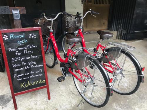 a red bike is parked next to a sign at Temple Lodging Shukubo Kakurinbo in Minobu