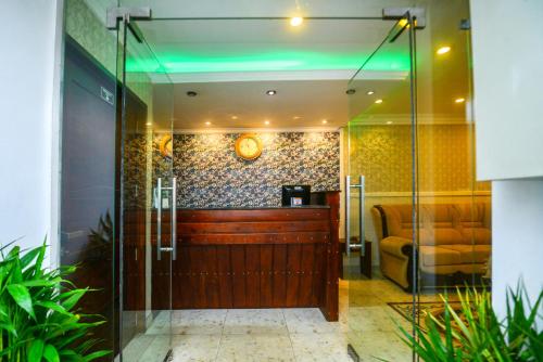 een glazen deur die leidt naar een kamer met een bank bij Galaxy Grand Hotel in Nuwara Eliya