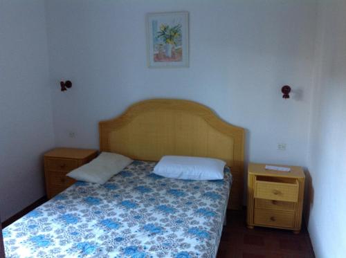 a small bedroom with a bed and a night stand at Apartament Turístic Alhambra in Platja d'Aro