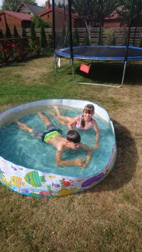 dos niños nadando en una piscina en un patio trasero en Vacation Without Make Up en Šventoji