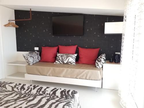a room with a bed with a tv on a wall at Hedoné Design Experience B&B in Agrigento