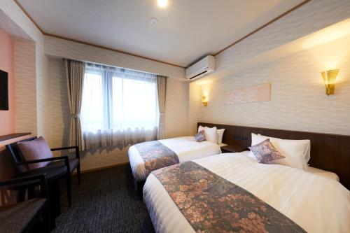 een hotelkamer met 2 bedden en een raam bij Rinn Miyagawacho Grande in Kyoto