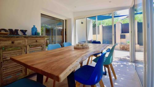 uma sala de jantar com uma mesa de madeira e cadeiras azuis em Charmante maison centre-ville Sainte-Maxime, plages à 2 pas em Sainte-Maxime