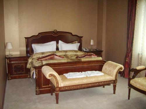 a bedroom with a large bed and a chair at Sunjin Grand Hotel in Ulaanbaatar