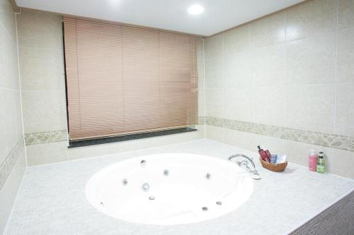 a bathroom with a large white tub in a room at Sunjin Grand Hotel in Ulaanbaatar