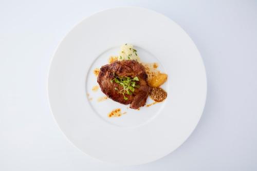 a plate of food with a piece of meat on it at Rembrandt Premium Fuji Gotenba in Gotemba