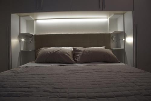 a bedroom with a bed with two lights above it at L'Orchidea Bianca in Cagliari
