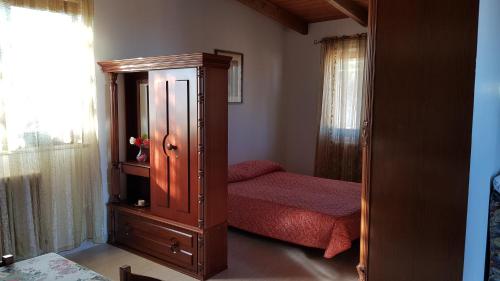 una camera con letto e armadio in legno di Chalet in campagna a Città Sant'Angelo