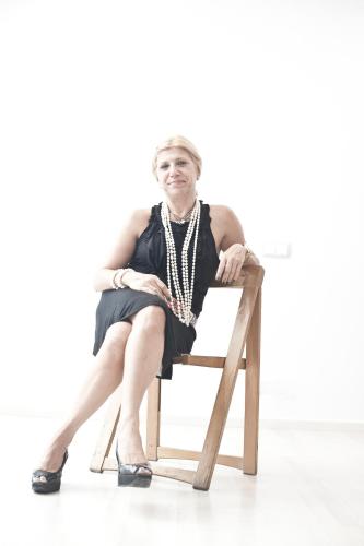 a woman in a dress sitting on a chair at Olmitos 3, Casa-Palacio Real Piedad in Cehegín
