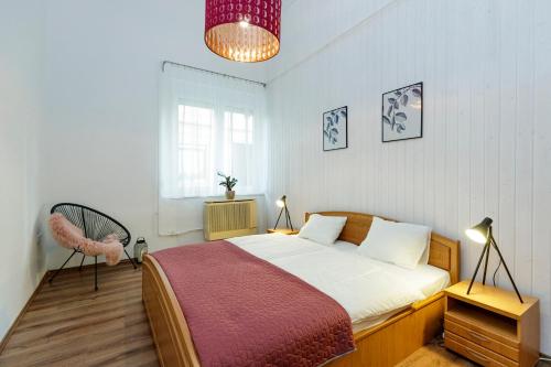 1 dormitorio con 1 cama, 1 silla y 1 ventana en SOPHIE Apartman, en Eger