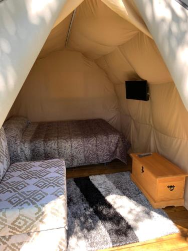 a bedroom in a tent with a bed and a television at Camping Santa Tecla in A Guarda