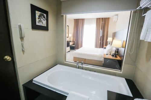 a bathroom with a sink and a large mirror at The Lake Hotel Tagaytay in Tagaytay