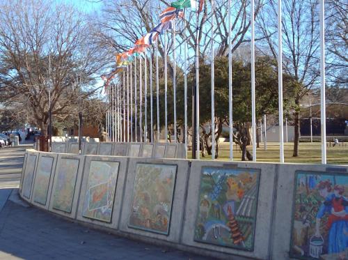 a fence with paintings on it in a park at iMotel Cooma (in town) in Cooma