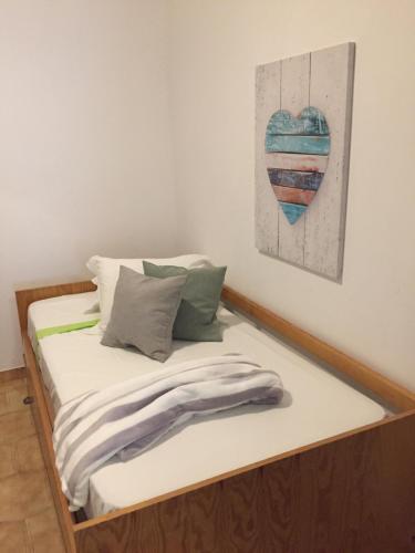 奎特里拉的住宿－Apartment Sea View 20m to beach - TOP Quarteira ALGARVE，墙上有心画的房间的一张床位