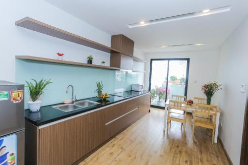 a kitchen with a sink and a table in it at Ficus Suites in Hanoi