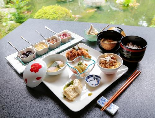 a table with a plate of food with chopsticks and bowls of food at Temple Lodging Shukubo Kakurinbo in Minobu