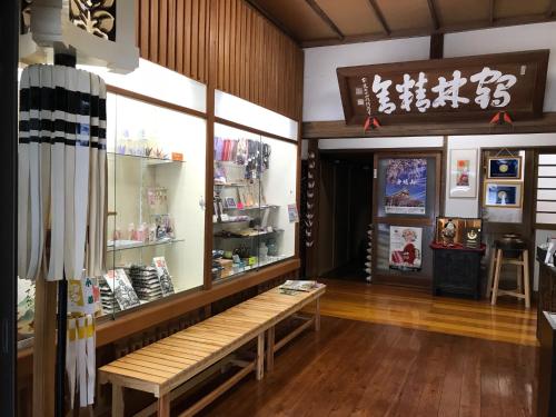 a store with a bench in front of a window at Temple Lodging Shukubo Kakurinbo in Minobu