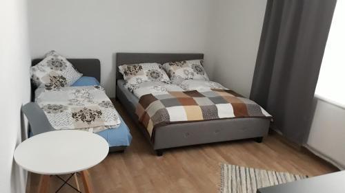 a small bedroom with a bed and a chair at Ubytovanie u Albína in Betlanovce
