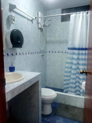 a bathroom with a shower and a toilet and a sink at Sunset Hostel Airport in Lima
